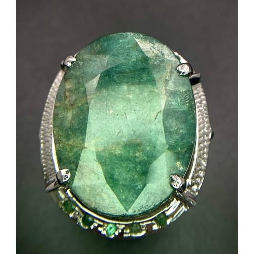 1123 - An Oval Slice Natural Emerald 925 Silver Ring with Emerald Accents. 20ct Emerald. Size Q. 14.88g tot... 