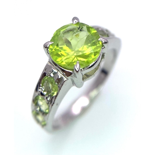 1722 - A 3ct Round Cut Peridot and 925 Silver Ring. Peridots on shoulders. Size O. 4g total weight. HV - 20... 