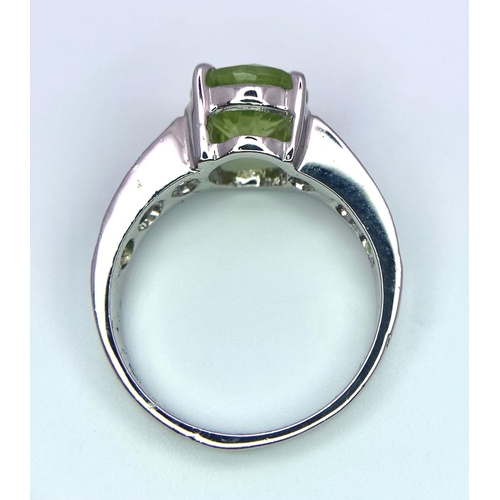 1722 - A 3ct Round Cut Peridot and 925 Silver Ring. Peridots on shoulders. Size O. 4g total weight. HV - 20... 