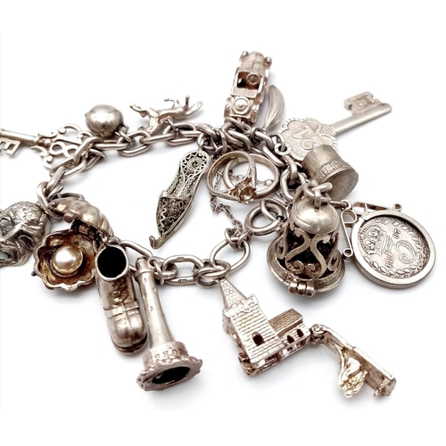 1787 - A well collected, white metal Charm Bracelet.
Full of eclectic charms, some stand-outs include a 189... 