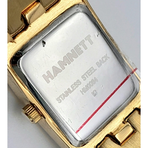 1387 - A Vintage Hamnett Ladies Watch. 
Gold Tone stainless steel with set crystals, unworn with protective... 