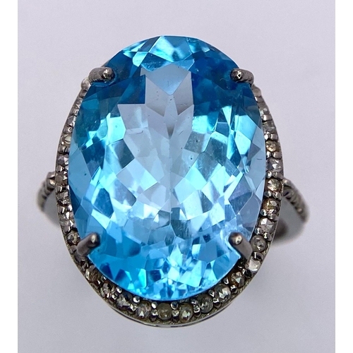 1075 - A Sky Blue Topaz and Diamond 925 Silver Ring. A 16ct oval topaz with a diamond halo and accents - 0.... 