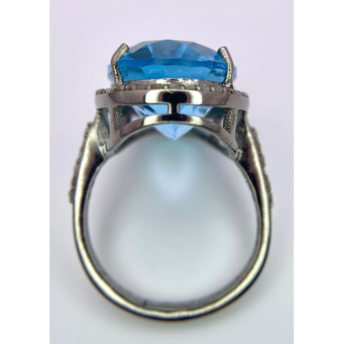 1075 - A Sky Blue Topaz and Diamond 925 Silver Ring. A 16ct oval topaz with a diamond halo and accents - 0.... 