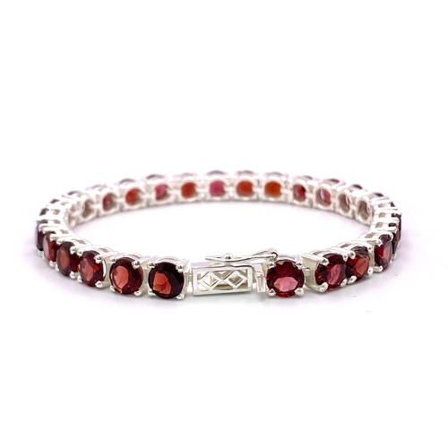 1422 - A Garnet Gemstone Tennis Bracelet set in 925 Silver. Round cut garnets. 18cm. 21.2g total weight. Re... 