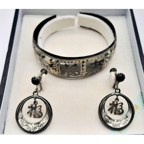 147 - A rare, vintage, sterling silver bangle and matching earrings set with Chinese characters. Total wei... 