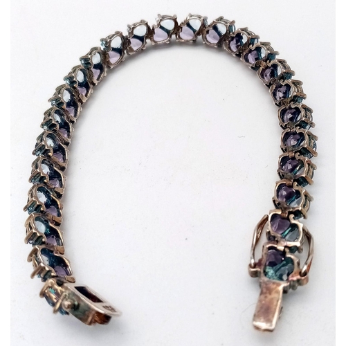 1606 - A Sterling Silver, double row bracelet set with Amethyst and Topaz. Measures 20cm in length.
Weight:... 