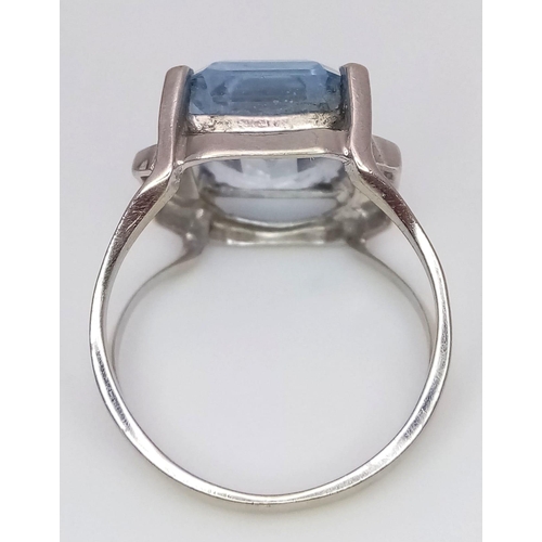 318 - An 18K White Gold Aquamarine Ring. Rectangular step cut on a raised setting. Size O. 5.35g total wei... 