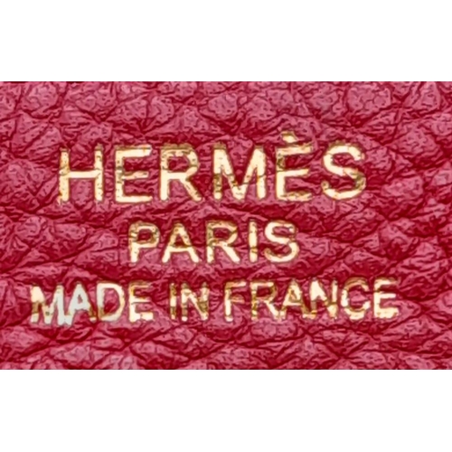 641 - A Hermes Red Kelly Bag. Veau togo leather exterior, with gold toned hardware, single handle, four pr... 