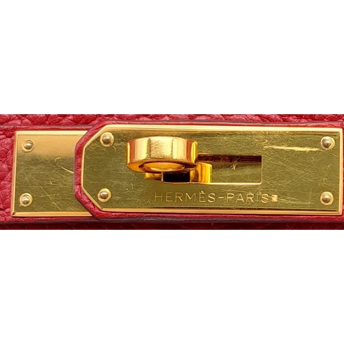 641 - A Hermes Red Kelly Bag. Veau togo leather exterior, with gold toned hardware, single handle, four pr... 