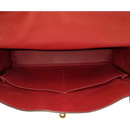 641 - A Hermes Red Kelly Bag. Veau togo leather exterior, with gold toned hardware, single handle, four pr... 