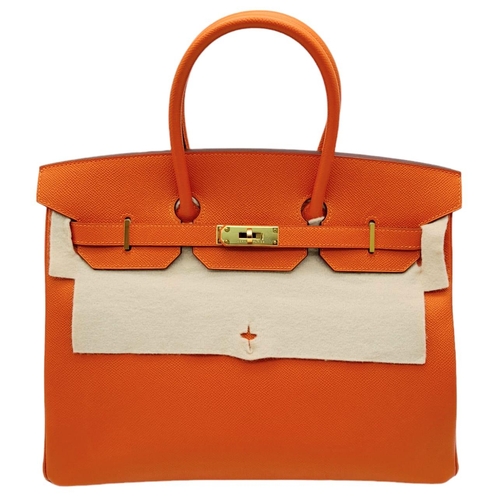 648 - Hermès Orange Togo Birkin Handbag. 
Iconic Orange paired with gold toned hardware is a brilliant pop... 