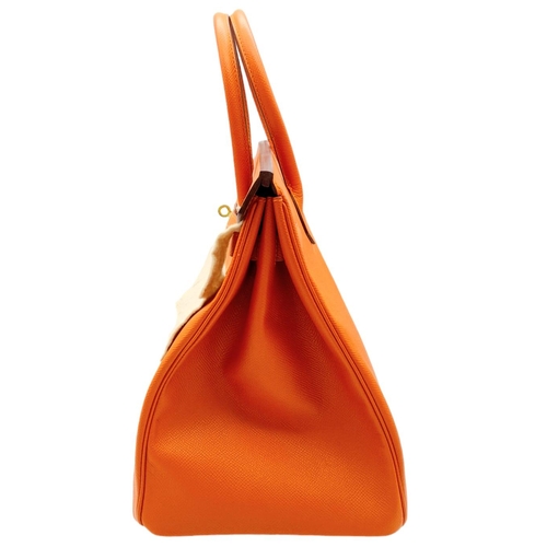 648 - Hermès Orange Togo Birkin Handbag. 
Iconic Orange paired with gold toned hardware is a brilliant pop... 