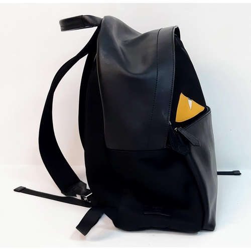 1201 - A Fendi Monster Black Backpack. Canvas and leather exterior, with two large yellow monster eyes, a z... 