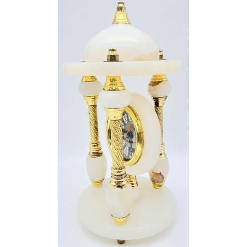 1608 - A Vintage White Onyx Mantle Clock.
Featuring three pillars, gold tone metal and elaborate patterning... 