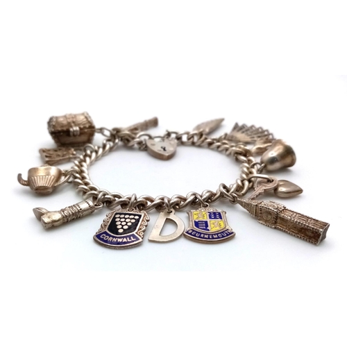 694 - A 1975, Birmingham Silver Charm Bracelet.
Filled with a great array pf charms, a treasure chest with... 