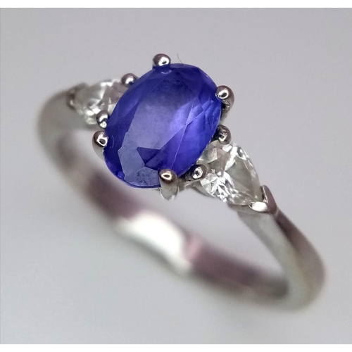 152 - A 18K WHITE GOLD DIAMOND & TANZANITE 3 STONE RING. 0.50CT OF PEAR SHAPE DIAMONDS & 0.85CT OVAL TANZA... 