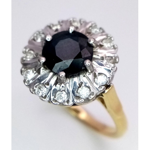 24 - An 18 K yellow gold ring with a round cut sapphire (1.25 carats) surrounded by a halo of diamonds. S... 