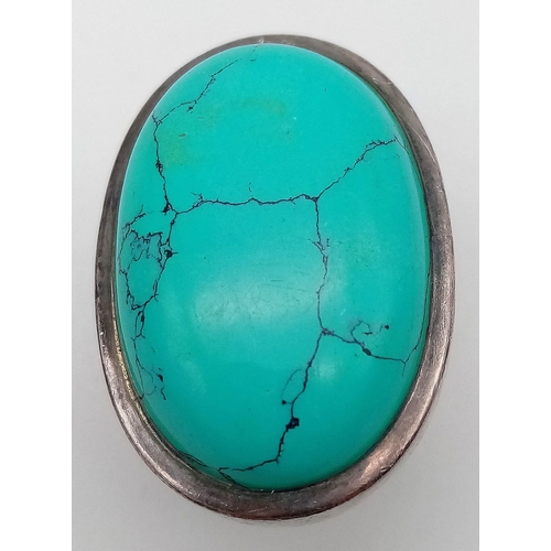 472 - A sterling silver ring with a large turquoise cabochon ( 32 x 21 x 6 mm). Ring size: T, weight: 25.2... 