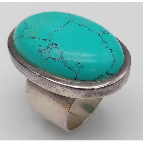 472 - A sterling silver ring with a large turquoise cabochon ( 32 x 21 x 6 mm). Ring size: T, weight: 25.2... 