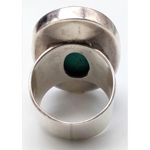 472 - A sterling silver ring with a large turquoise cabochon ( 32 x 21 x 6 mm). Ring size: T, weight: 25.2... 