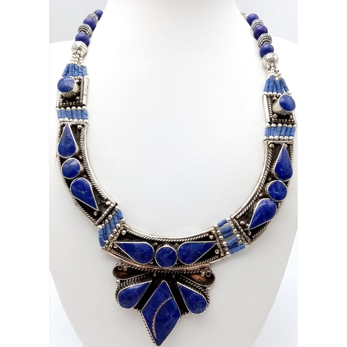 765 - A Lapis Lazuli Jewellery Suite. To include: Egyptian style choker necklace - 38cm. Decorative oval b... 