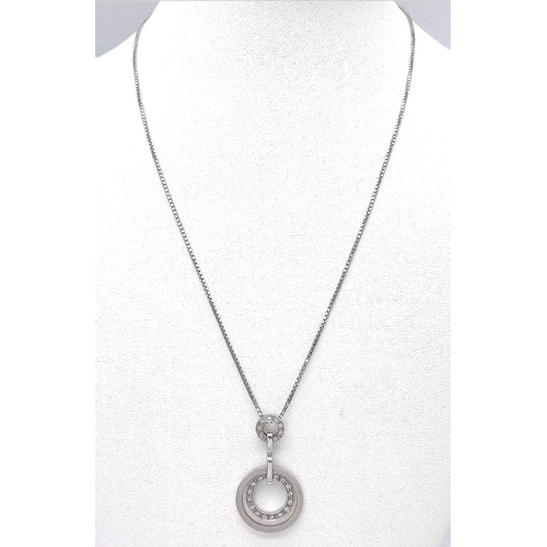 93 - An 18K White Gold Diamond Set Circular Articulated Pendant on a Box Chain. 7.9g total weight. 16