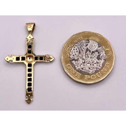 479 - A 9 K yellow gold cross with sapphires and diamonds. Length (with bail): 35 mm, weight: 1.3 g.