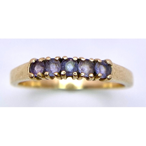 548 - A 9 K yellow gold ring with a band of light blue sapphires. Size: P, weight: 2.1 g.