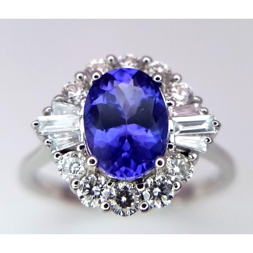 666 - An 18K White Gold Oval Tanzanite and Diamond Cluster Ring. Tanzanite - 1.54ct. Diamonds - 0.57ctw. S... 