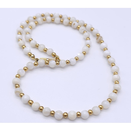 713 - A VERY ATTRACTIVE CHOKER NECKLACE WITH WHITE MARBLEISED BEADS AND GOLD PLATED SPACERS .    13.2gms  ... 