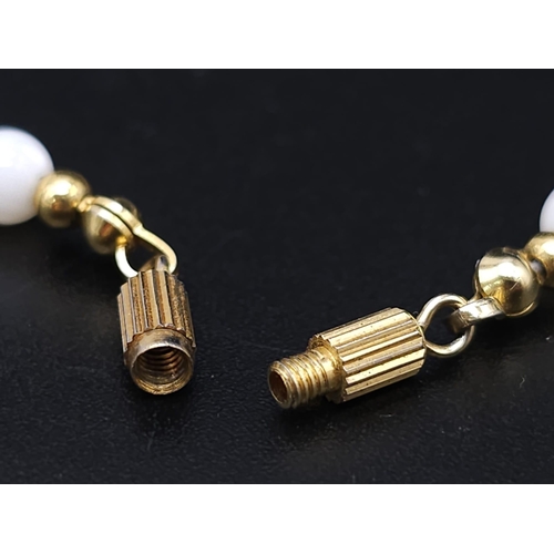 713 - A VERY ATTRACTIVE CHOKER NECKLACE WITH WHITE MARBLEISED BEADS AND GOLD PLATED SPACERS .    13.2gms  ... 