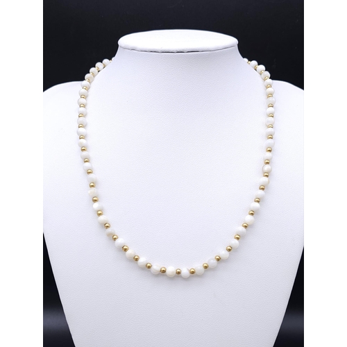 713 - A VERY ATTRACTIVE CHOKER NECKLACE WITH WHITE MARBLEISED BEADS AND GOLD PLATED SPACERS .    13.2gms  ... 