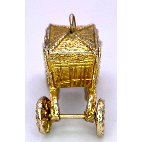 372 - A 9K Yellow Gold Royal Carriage Charm with Moving Wheels. Approximately 24mm wide, 4.2g weight.