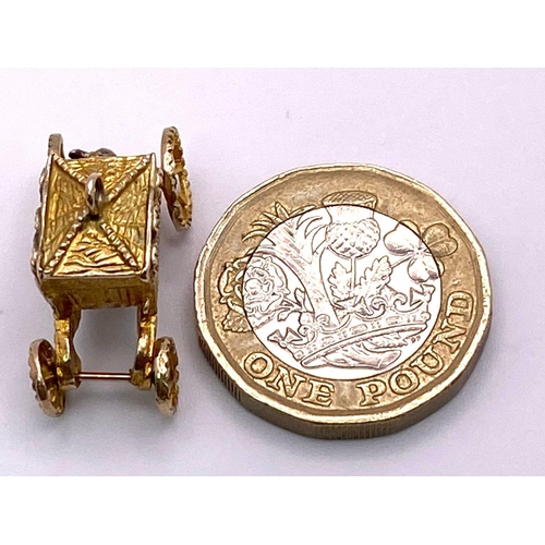 372 - A 9K Yellow Gold Royal Carriage Charm with Moving Wheels. Approximately 24mm wide, 4.2g weight.