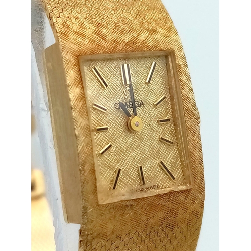 420 - A VINTAGE LADIES 14K GOLD OMEGA CLASSIC 17 JEWELS MANUAL WIND WRIST WATCH WITH PATTERNED GOLD TONE D... 