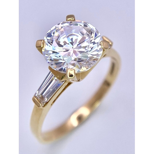 135 - A VERY IMPRESSIVE 14K GOLD RING WITH A 3ct ZIRCONIA STONE AND BAGUETTES SHOULDERS .     4.5gms   siz... 