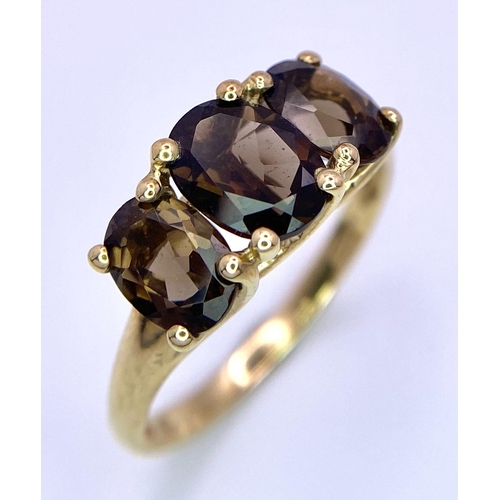 562 - A 9K GOLD RING WITH 3 SMOKEY QUARTZ STONES   2.4gms   size Q