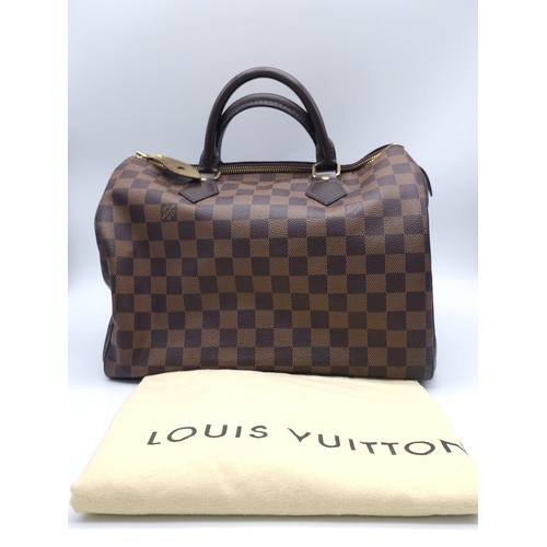 366 - A Louis Vuitton Speedy Damier Ebene Handbag. A leather exterior, with two rolled handles, gold toned... 