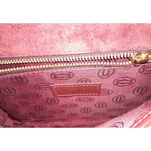 402 - Cartier Burgundy Shoulder Bag.
Quality soft leather exterior with rich suede accents, embossed C mot... 