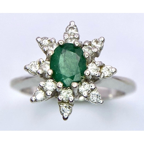 121 - AN 18K (TESTED) WHITE GOLD RING WITH CENTRAL EMERALD SURROUNDED BY DIAMONDS IN A FLORAL FORM  .   4.... 