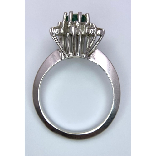 121 - AN 18K (TESTED) WHITE GOLD RING WITH CENTRAL EMERALD SURROUNDED BY DIAMONDS IN A FLORAL FORM  .   4.... 