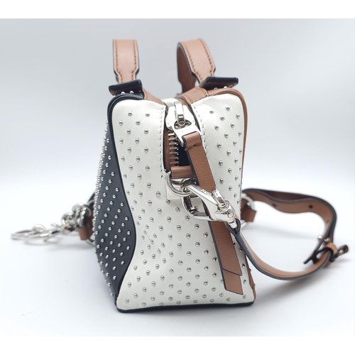 416 - A Tod's Mini Gommino Bag. Studded leather exterior with two handles, silver toned hardware, top zip ... 