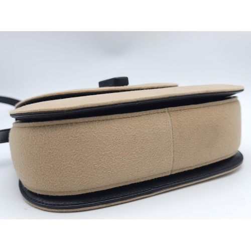 218 - Gucci Tan Wool Purse.
This Gucci tan wool purse features a black bar closure, black leather handle, ... 