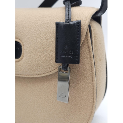 218 - Gucci Tan Wool Purse.
This Gucci tan wool purse features a black bar closure, black leather handle, ... 