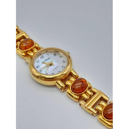 1209 - An Unworn Ladies Gold Tone Amber Set Quartz Watch by the Jeweller Lee Sands. 
19cm Length including ... 