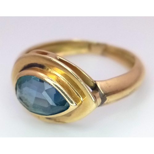 288 - An 18K Yellow Gold Blue Gemstone (possibly topaz) Ring. Pear shaped stone set within a raised founda... 