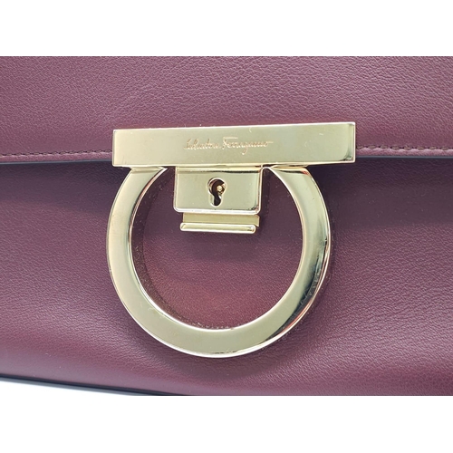 468 - Salvatore Ferragamo Leather Burgundy Shoulder Bag.
Comes with tasselled and woven vanity mirror with... 