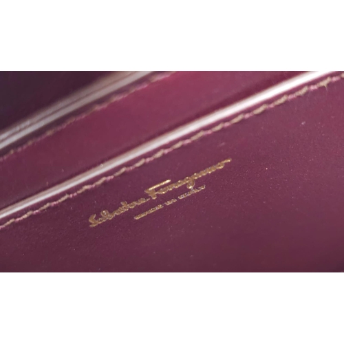 468 - Salvatore Ferragamo Leather Burgundy Shoulder Bag.
Comes with tasselled and woven vanity mirror with... 