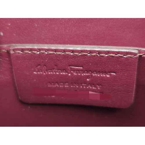 468 - Salvatore Ferragamo Leather Burgundy Shoulder Bag.
Comes with tasselled and woven vanity mirror with... 