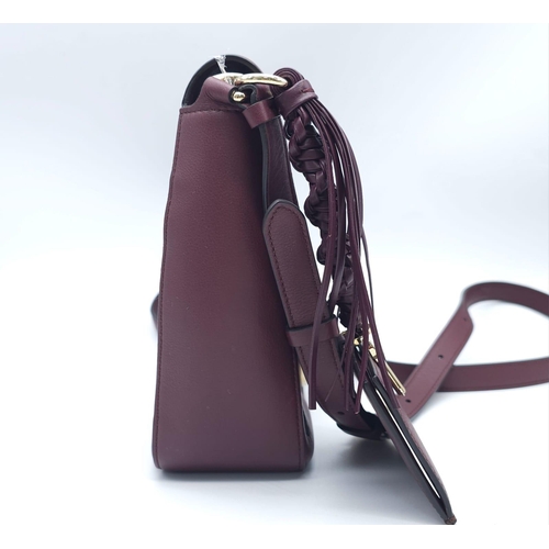 468 - Salvatore Ferragamo Leather Burgundy Shoulder Bag.
Comes with tasselled and woven vanity mirror with... 